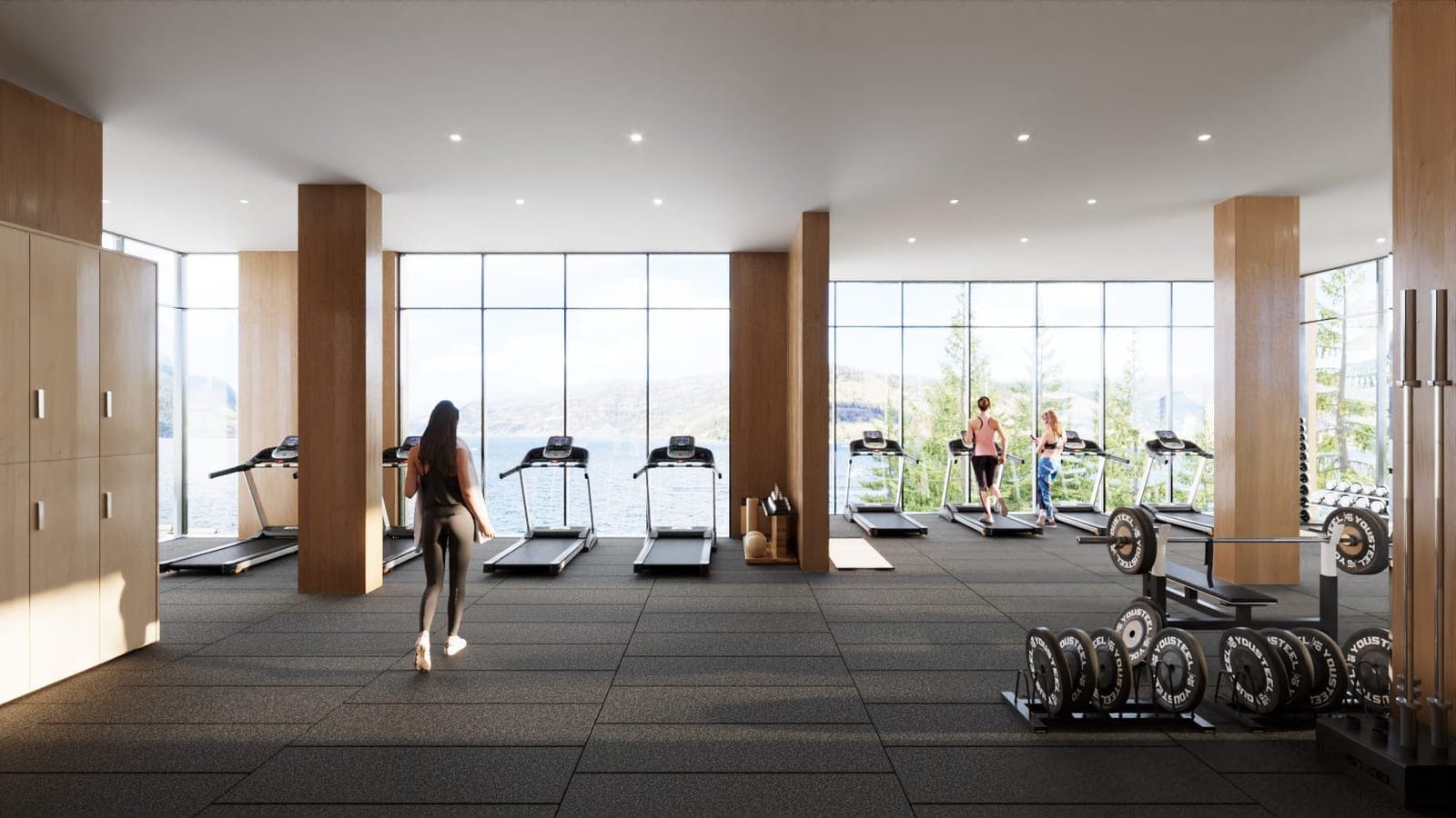Residents working out in the fitness centre with views of Okanagan Lake