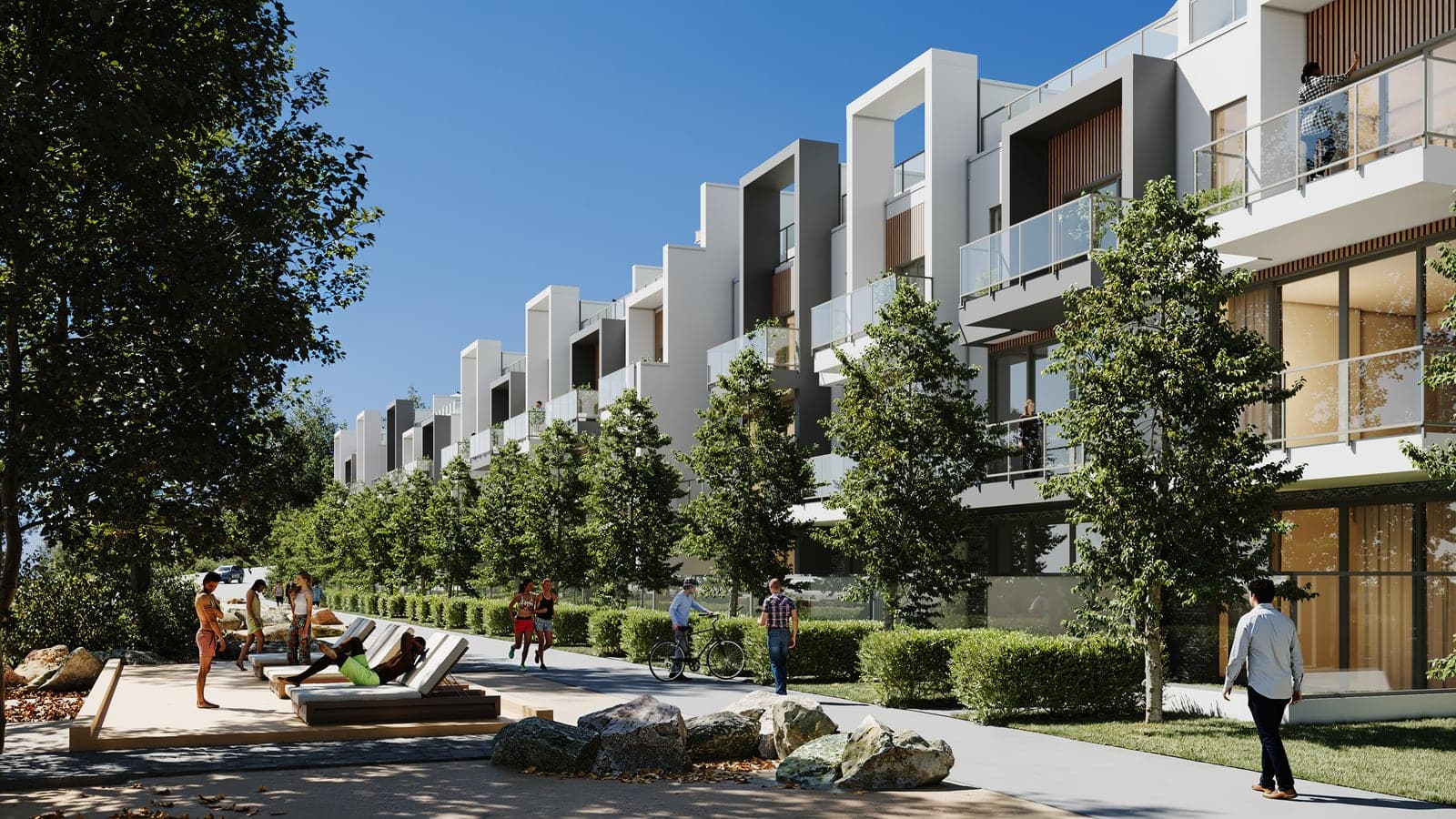 People walking, cycling and lounging on the lakefront path beside the waterfront villas on a summer day