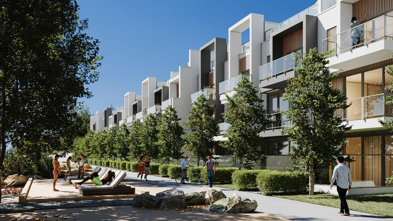 People walking, cycling and lounging on the lakefront path beside the waterfront villas on a summer day