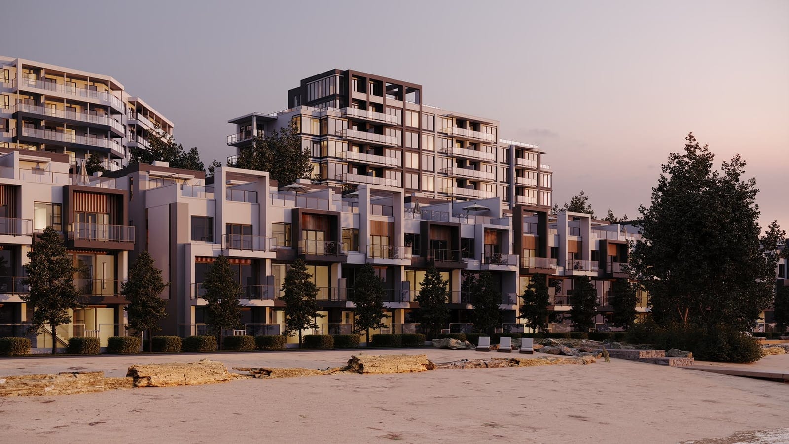 Waterfront villas at dusk with lit windows, seen from the beach, the Waterfront Tower behind