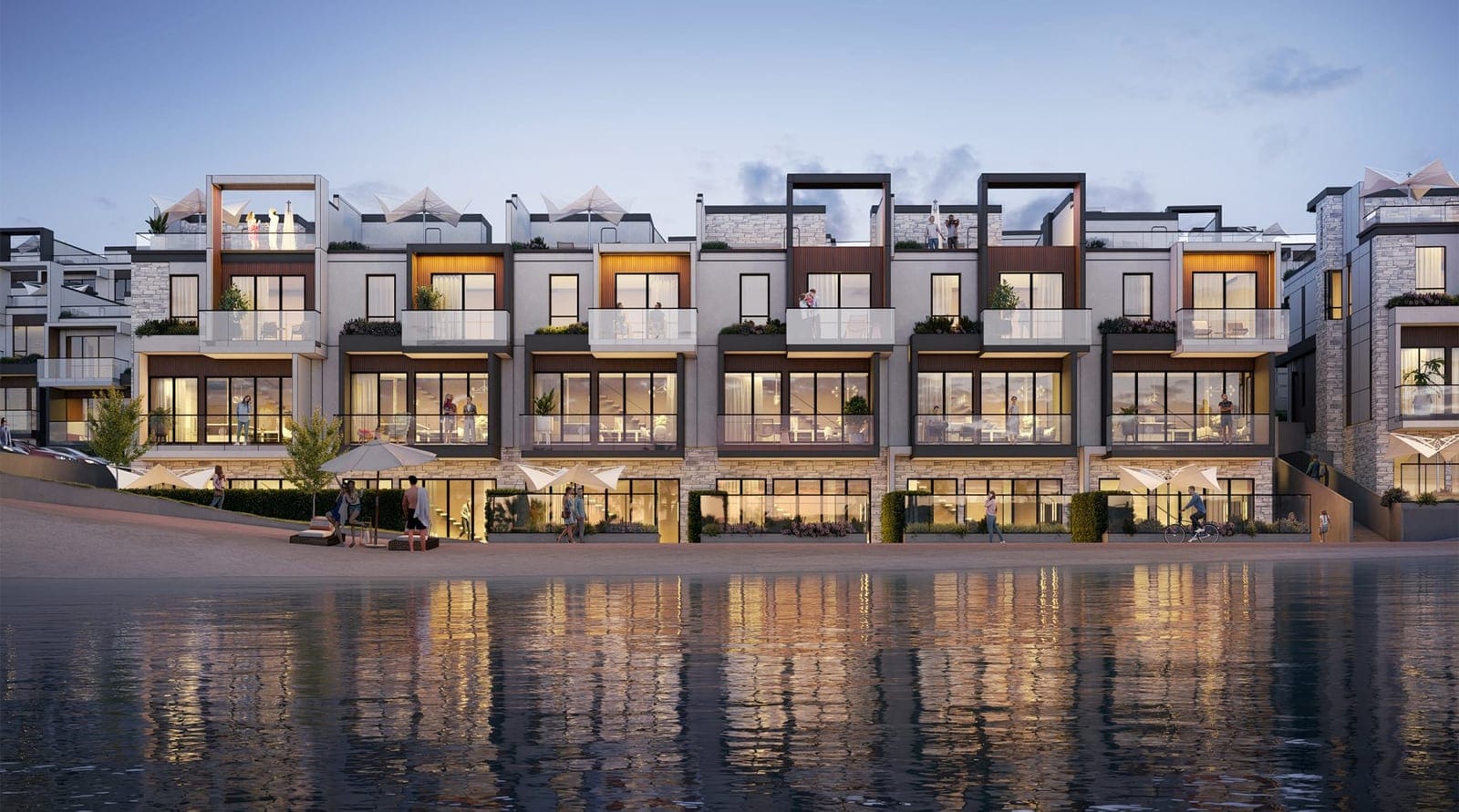 Waterfront villas lit at dusk and reflected in Okanagan Lake