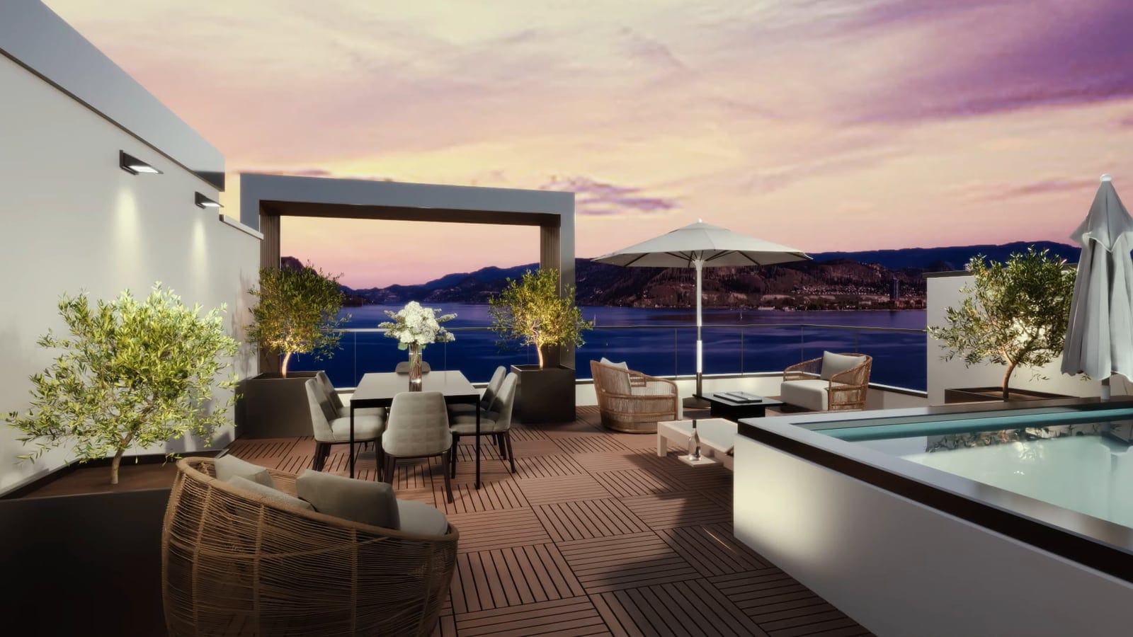 A villa rooftop terrace at dusk, with a dining table, lounge chairs and a hot tub above Okanagan Lake
